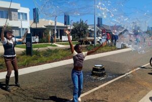 Euphoric girl with a giant bubble by the Bubble Sisters.